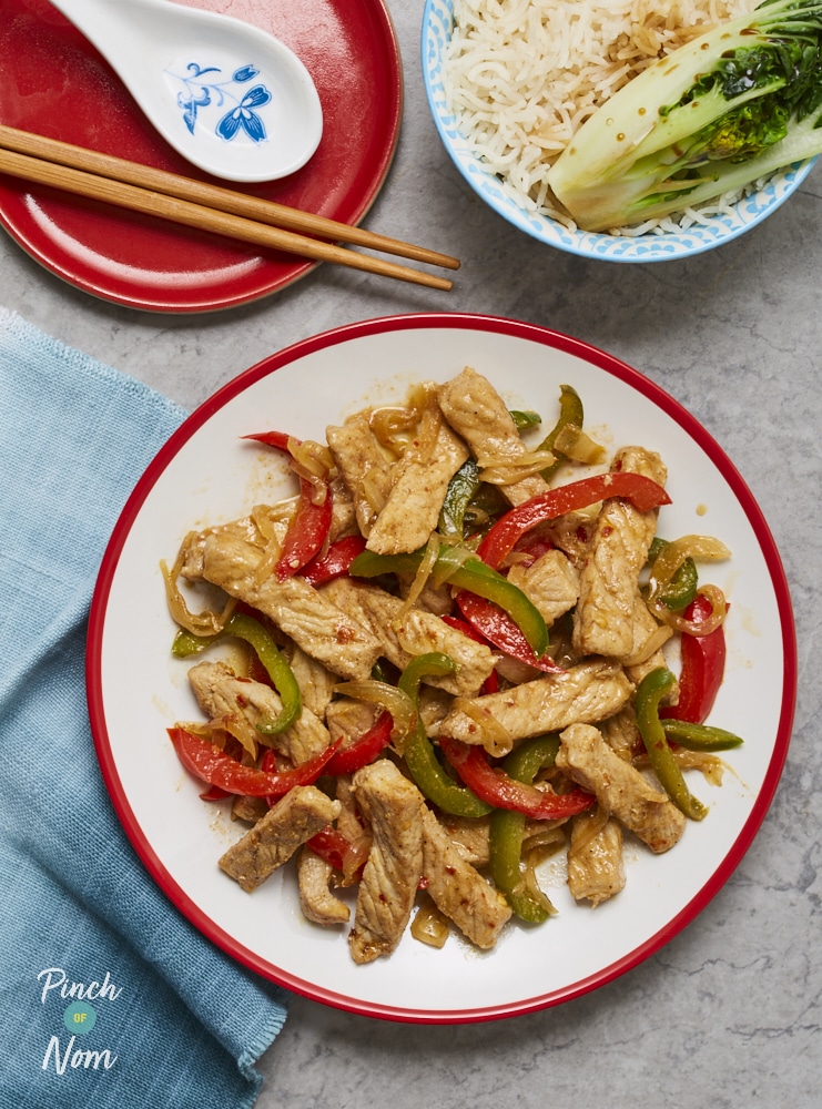 Pinch of Nom's slimming-friendly Salt and Pepper Pork is plated up at the centre of a table with chopsticks ready to tuck in, and a separate side portion of rice and pak choi.