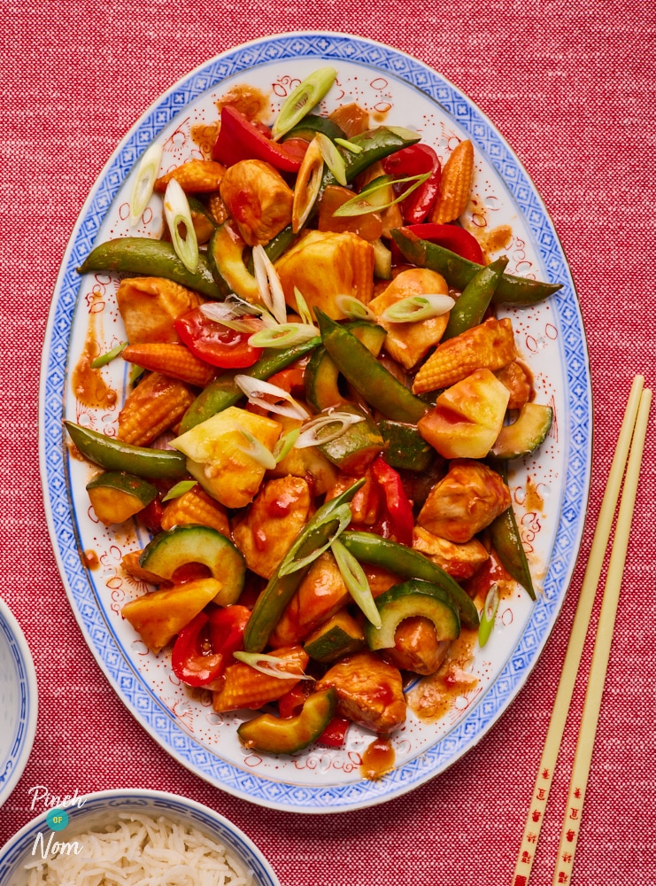 Pinch of Nom's slimming-friendly Sweet and Sour Chicken fakeaway is served at the centre of a table with chopsticks alongside, ready to dig in.
