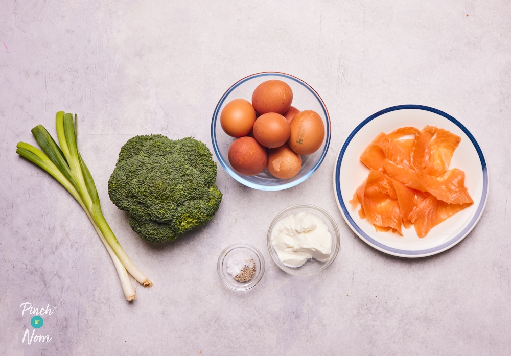 The raw ingredients for Pinch of Nom's slimming-friendly Smoked Salmon and Broccoli Quiche are laid out on a kitchen counter, ready to begin cooking.