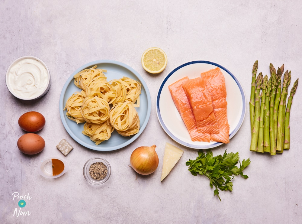 The raw ingredients for Pinch of Nom's slimming-friendly Creamy Salmon and Asparagus Pasta are laid out on a kitchen counter, ready to begin cooking.