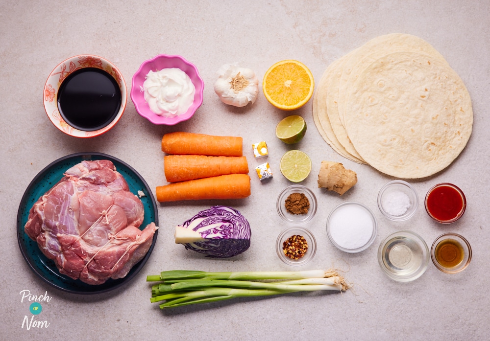 The raw ingredients for Pinch of Nom's slimming-friendly Slow Cooker Spiced Pulled Pork are laid out on a kitchen counter, ready to begin cooking.