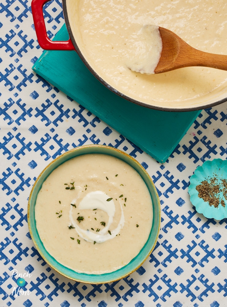 A bowl is filled with Pinch of Nom's White Onion Soup, topped with an extra swirl of cream and chives.