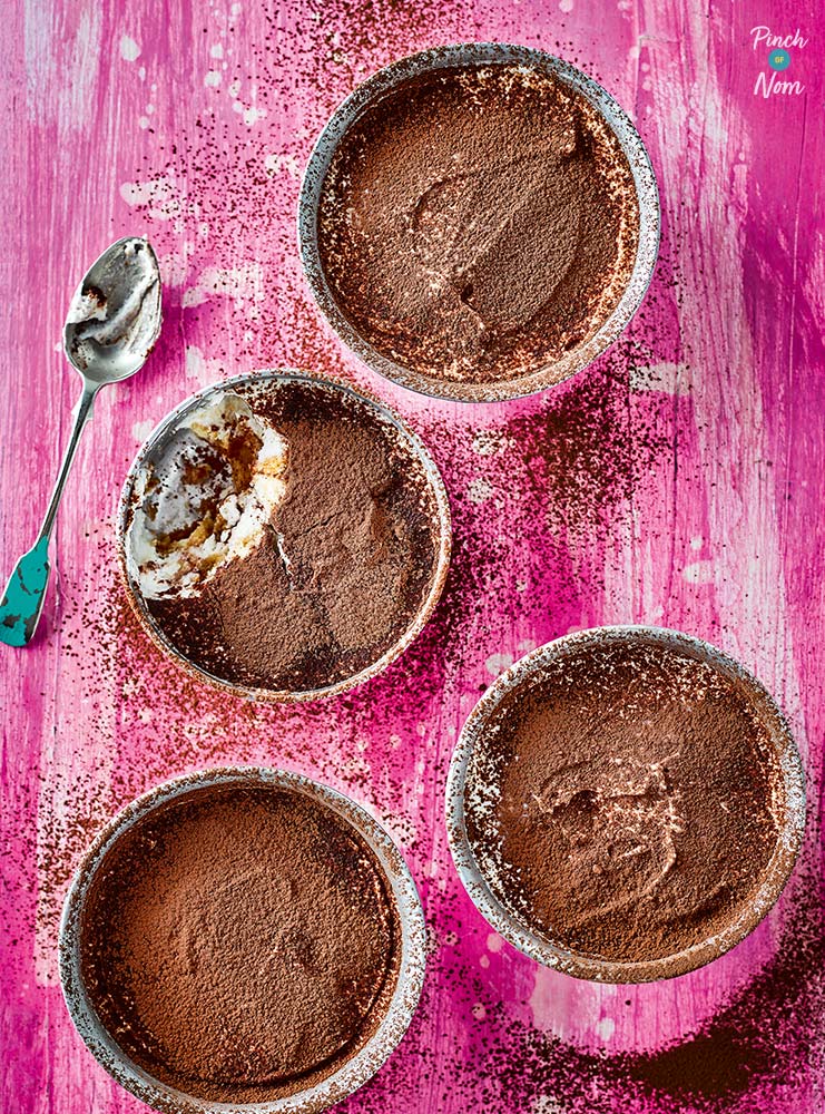 Pinch of Nom's slimming-friendly Tiramisu from the first Pinch of Nom book is served in four individual ramekins on a bright pink tabletop.