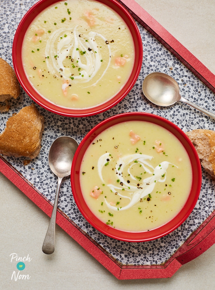 A tray is filled with two bowls of Pinch of Nom's Salmon, Leek and Potato Soup, next to pieces of wholemeal bread roll waiting to be dunked.