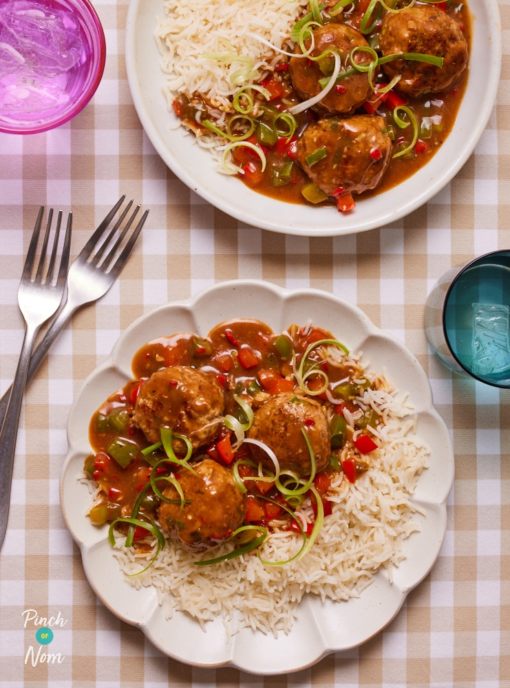 A table is set with two plates of Pinch of Nom's slimming-friendly Hoisin Turkey Meatballs. Both portions are served with a fluffy side of basmati rice.