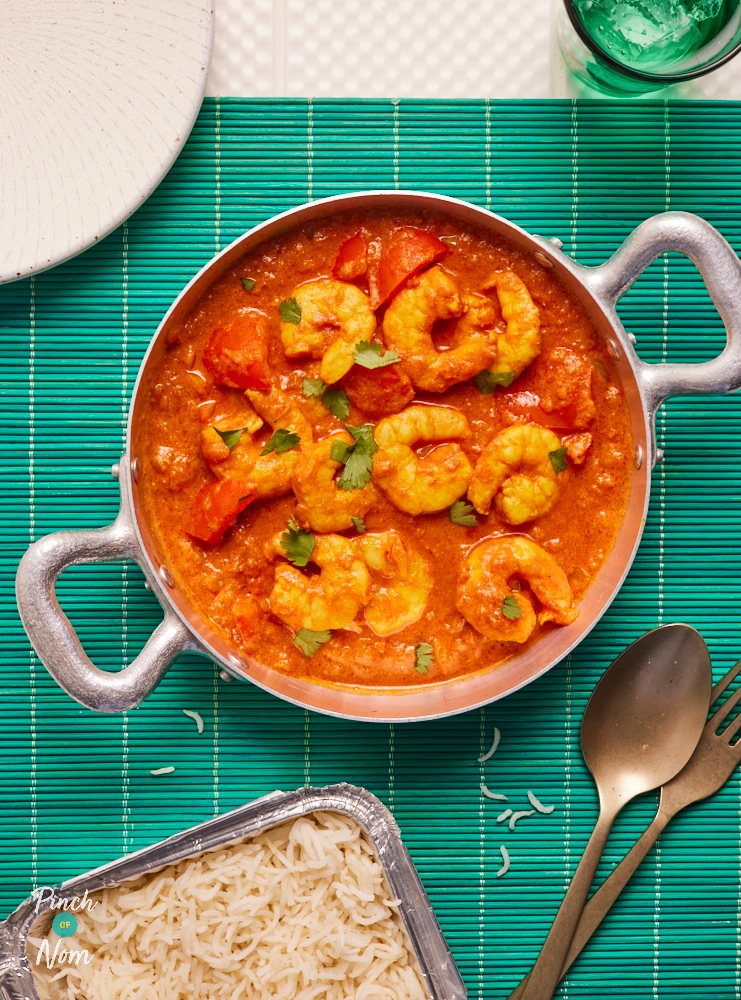 Pinch of Nom's slimming-friendly Prawn Tikka Masala is served at the centre of a table with a fluffy side of basmati rice.