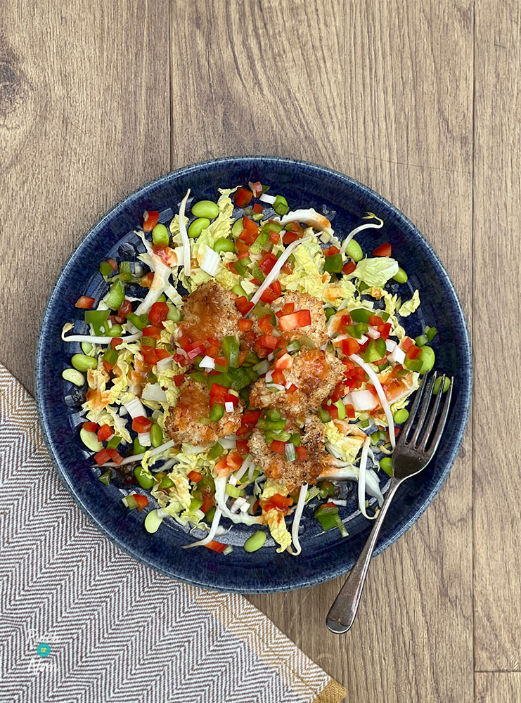 A table is set with Pinch of Nom's slimming-friendly Salt and Pepper Chicken Salad from the Express cookbook.