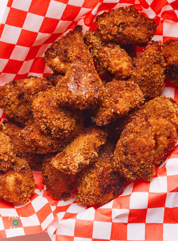 A close-up shot of the golden brown Chipotle Popcorn Chicken in a basket lined with red and white chequered paper.