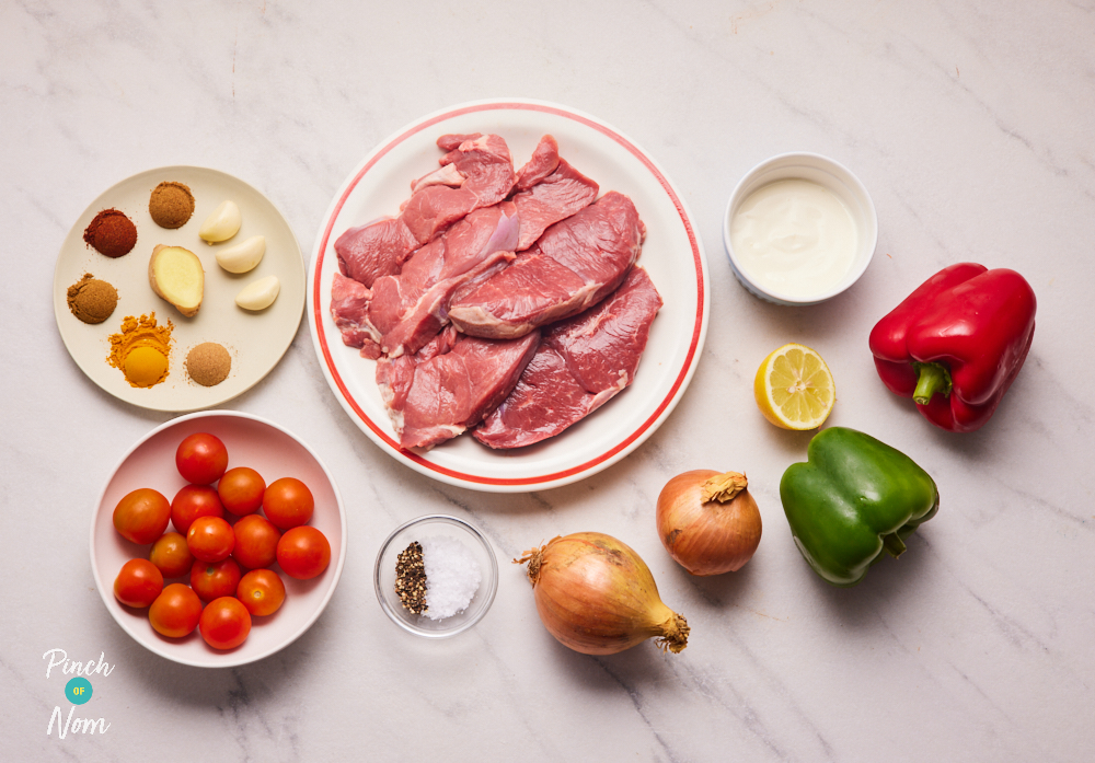 The ingredients for Pinch of Nom's Indian-Spiced Lamb Kebabs fakeaway are laid out on a kitchen counter, ready to start cooking.