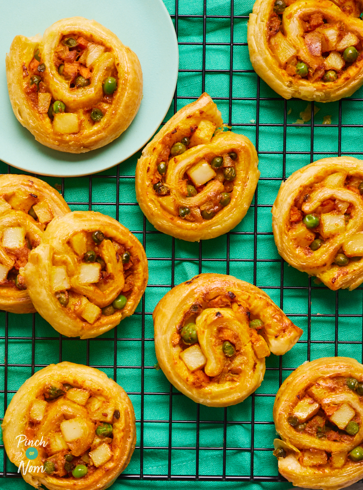 A close-up of Pinch of Nom's Samosa Swirls served golden brown and fresh from the oven on a cooling rack.