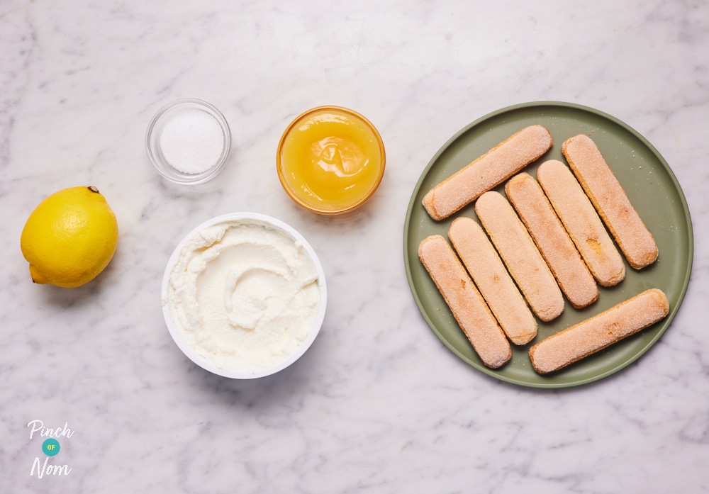 The ingredients for Pinch of Nom's slimming-friendly Lemon Tiramisu are laid out on a kitchen surface. Each ingredient is measured out, ready to begin cooking.