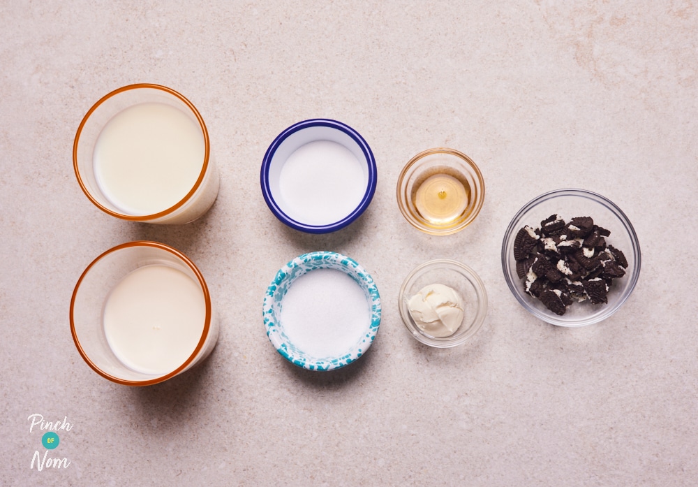 The ingredients for Pinch of Nom's low-calorie NInja Creami Cookies and Cream Ice Cream are laid out on a kitchen counter, ready to begin making the recipe.