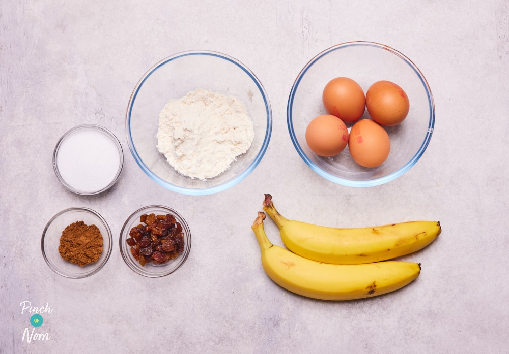 The raw ingredients for Pinch of Nom's Banana Bread Pudding are laid out on a kitchen counter, ready to begin baking.