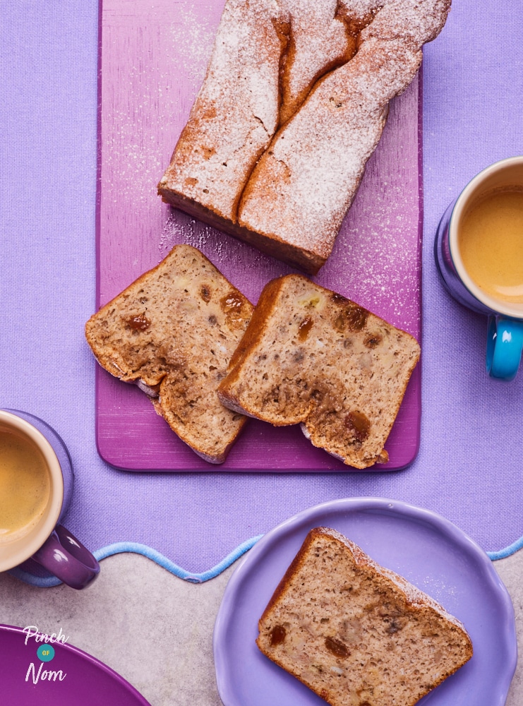 On a bright purple tabletop and serving board, Pinch of Nom's slimming-friendly Banana Bread Pudding is served; a few slices have already been dished out onto small serving plates and paired with a warm cuppa.