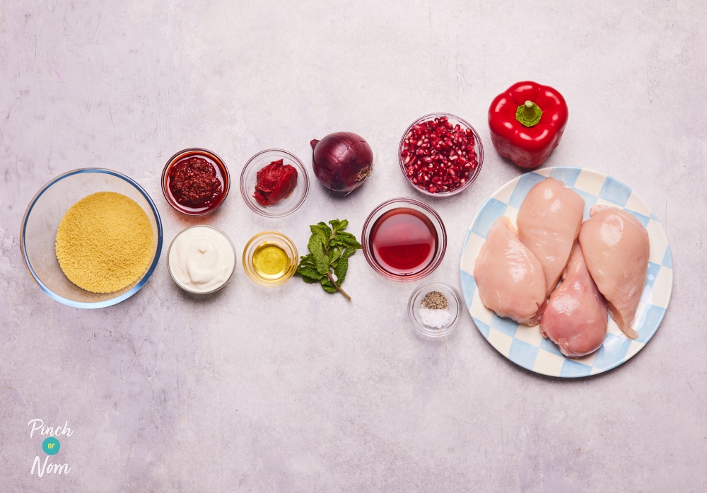 The ingredients for Pinch of Nom's Pomegrante and Harissa Chicken are laid out on a kitchen counter, ready to begin cooking.