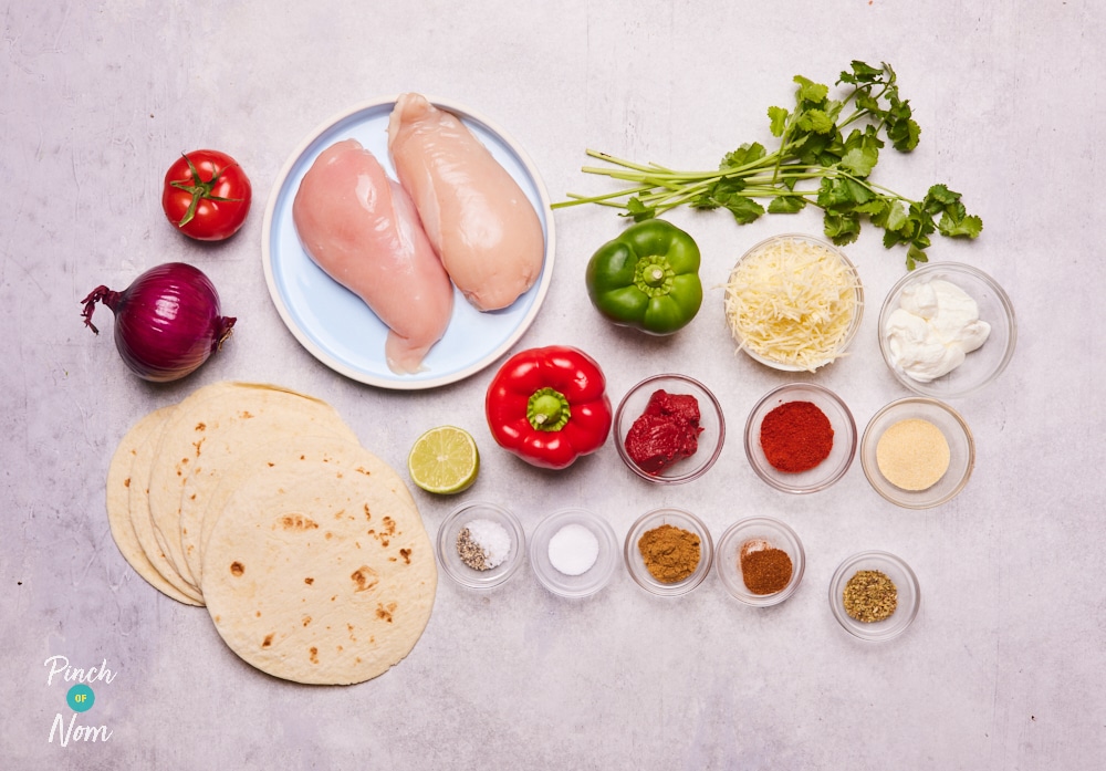 The raw ingredients for Pinch of Nom's slimming-friendly Chicken Tacos are laid out on a kitchen counter, ready to begin cooking.