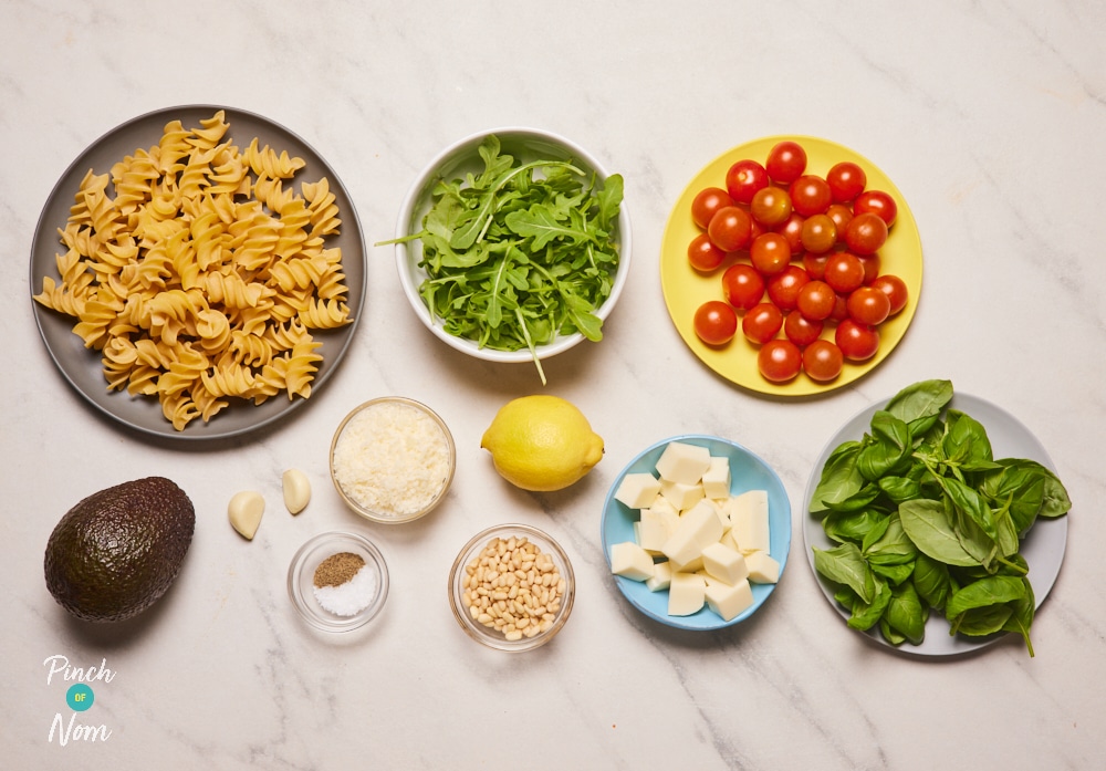 The raw ingredients for Pinch of Nom's slimming-friendly Pesto Pasta Salad are laid out on a kitchen counter, ready to begin cooking.